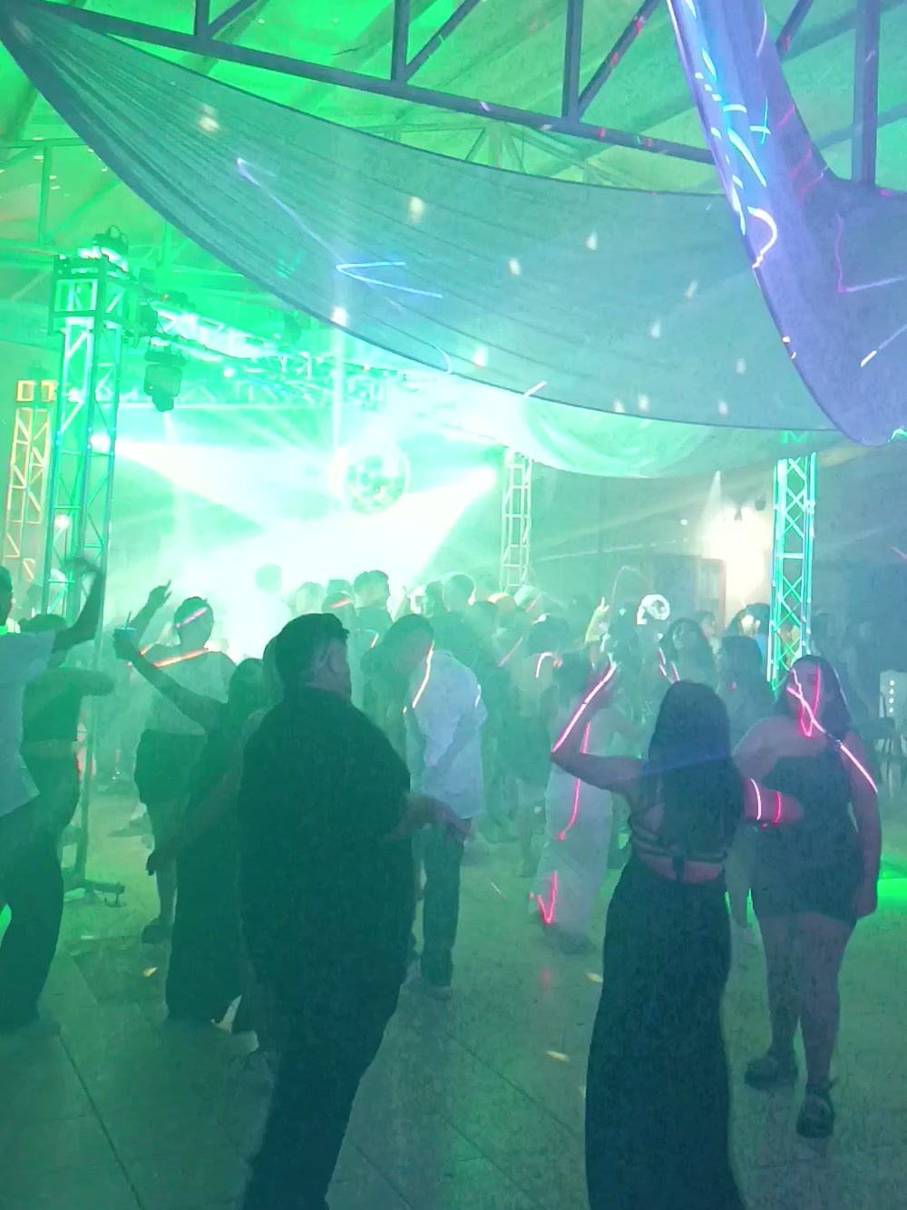 Pista llena de invitados bailando con varitas luminosas en una fiesta de 15 en Mendoza